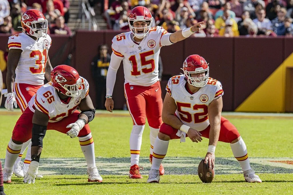 
Patrick Mahomes (#15), rozgrywający drużyny Kansas City Chiefs, wywołuje zagranie podczas meczu z Washington Football Team na stadionie FedEx Field w Landover, 2021 r.